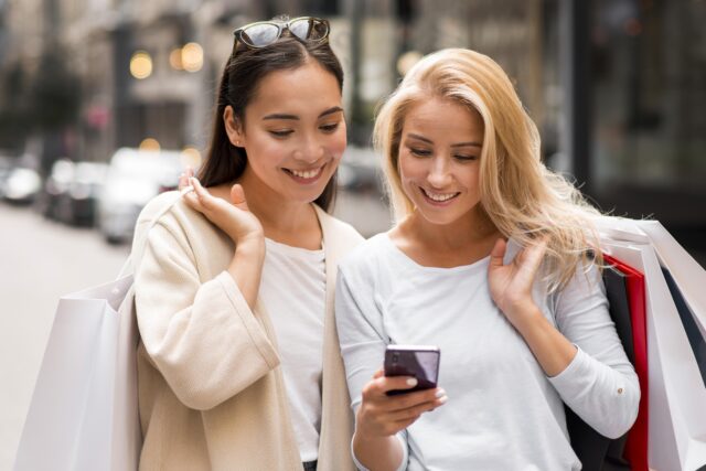 https://titantechemirates.com/wp-content/uploads/2024/08/two-women-holding-shopping-bags-looking-smartphone-640x427.jpg